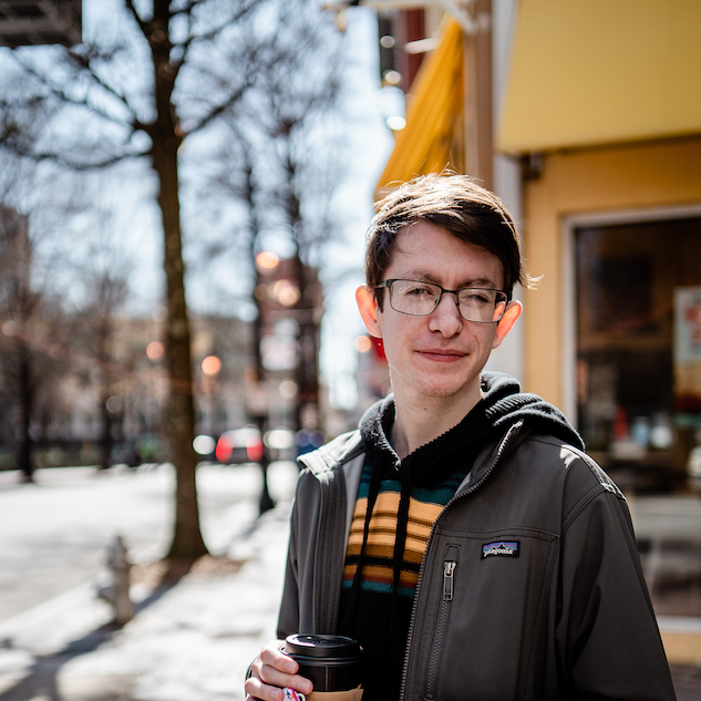 Eliot standing outside with coffee.