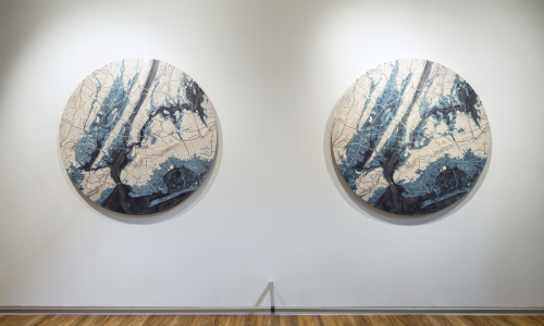 A photograph of Maya Lin’s 2°C / 4°C on display at the Smith College Museum of Art in 2022 (from SCMA, 2022). These encaustic, ink, and bond paper wall pieces depict expected flood zones in New York City by 2100. The artworks show the area that will be underwater (in blue) if global temperatures rise 2°C (left) and 4°C (right). Dark blue represents bodies of water in 2022, and the lighter blue shows additional flooded areas. Note the greater extent of light blue areas in the image to the right.